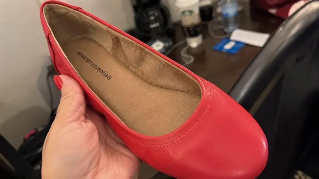 A close look at the inner cushioning and footbed of the bright red flat shoe.