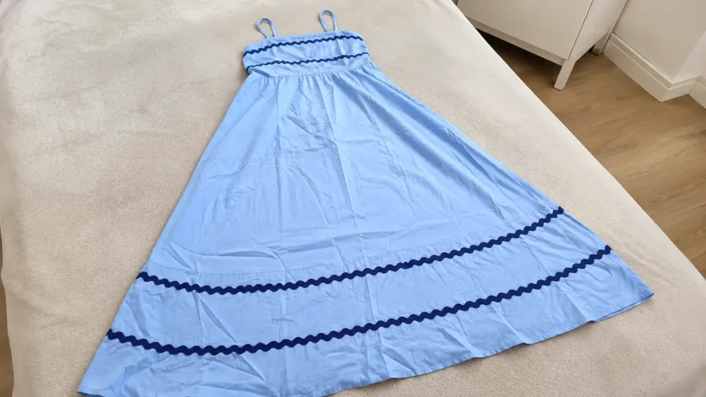 The dress laid out with visible wrinkles after being removed from packaging